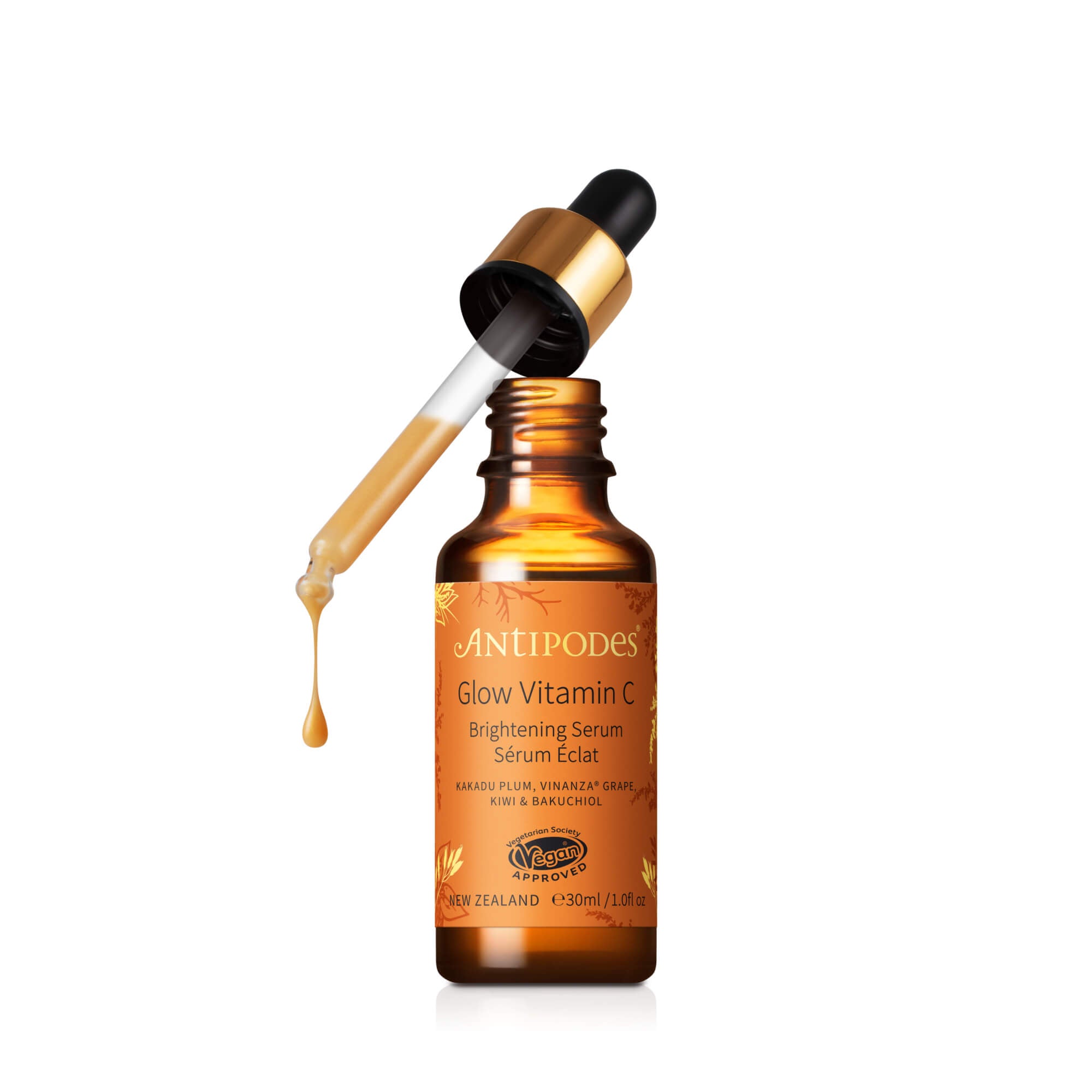 A bottle of Antipodes Glow Ritual Vitamin C Serum with plant hyaluronic acid, showing a golden dropper and orange-colored liquid inside.