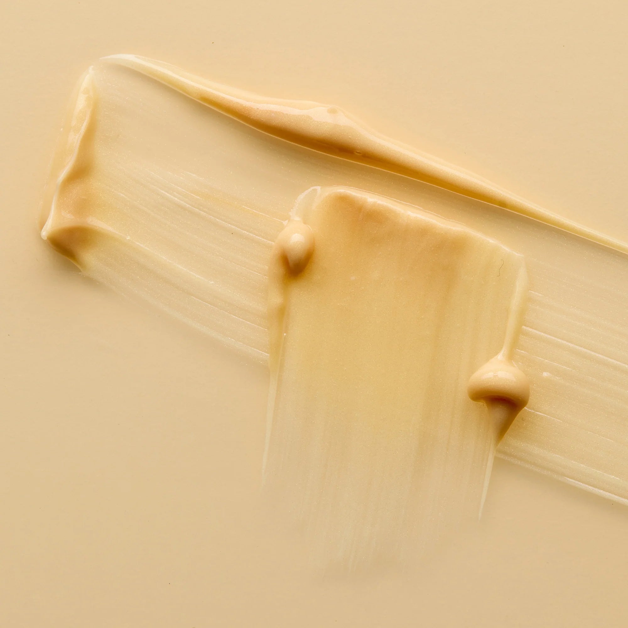 Close-up of beige cream of Antipodes Diem with smears and dots on a beige background