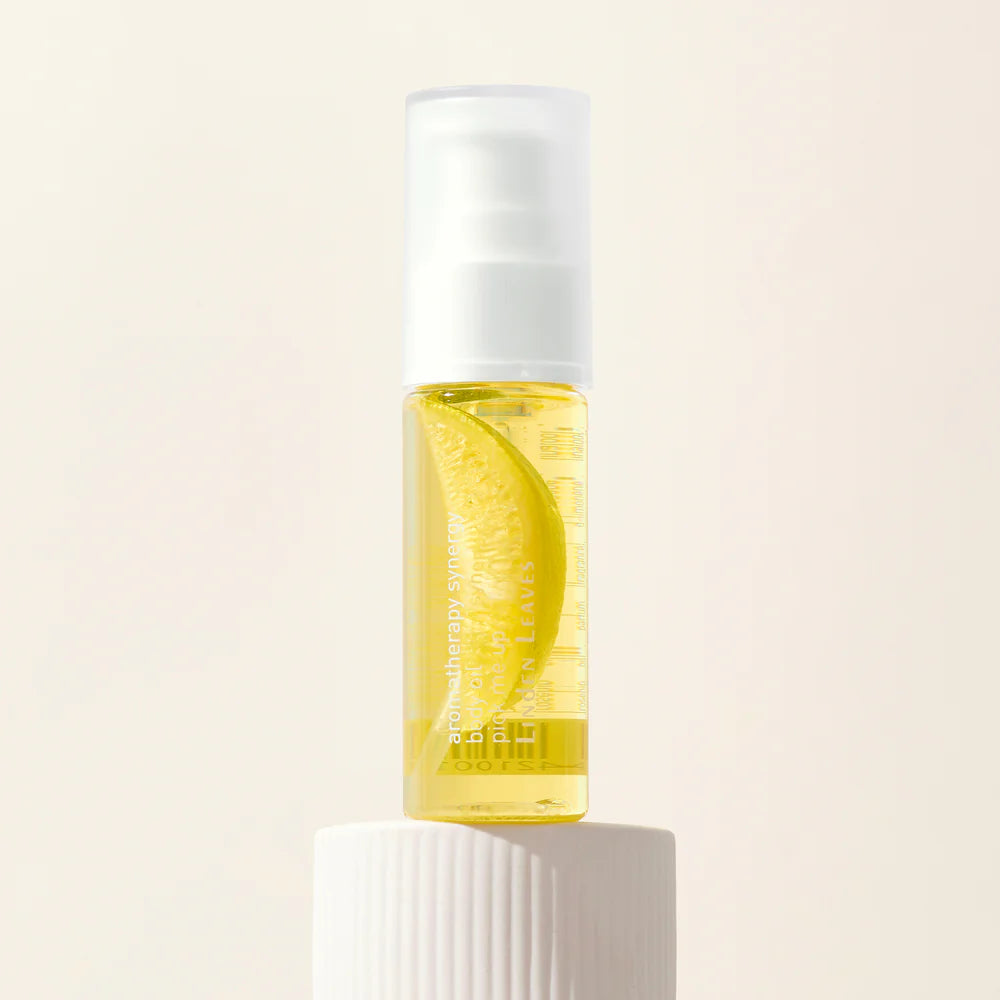 Linden Leaves Pick Me Up body oil with a lemon slice design on a light beige background