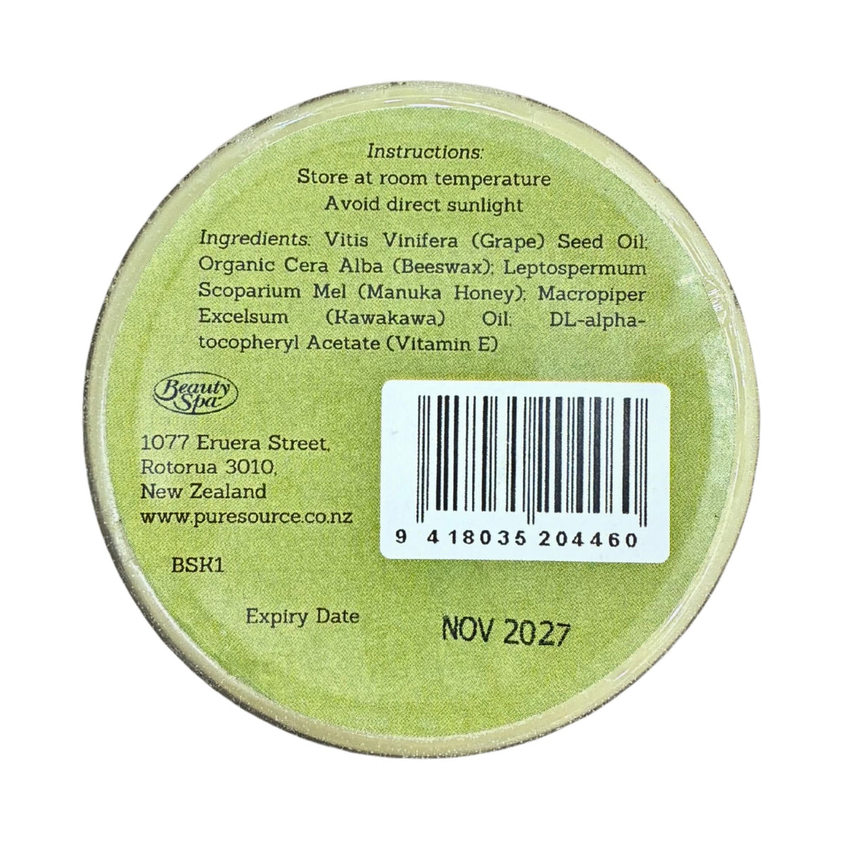 The back of a round cosmetic tin showing product instructions, ingredients, a barcode, and expiry date on a white background.