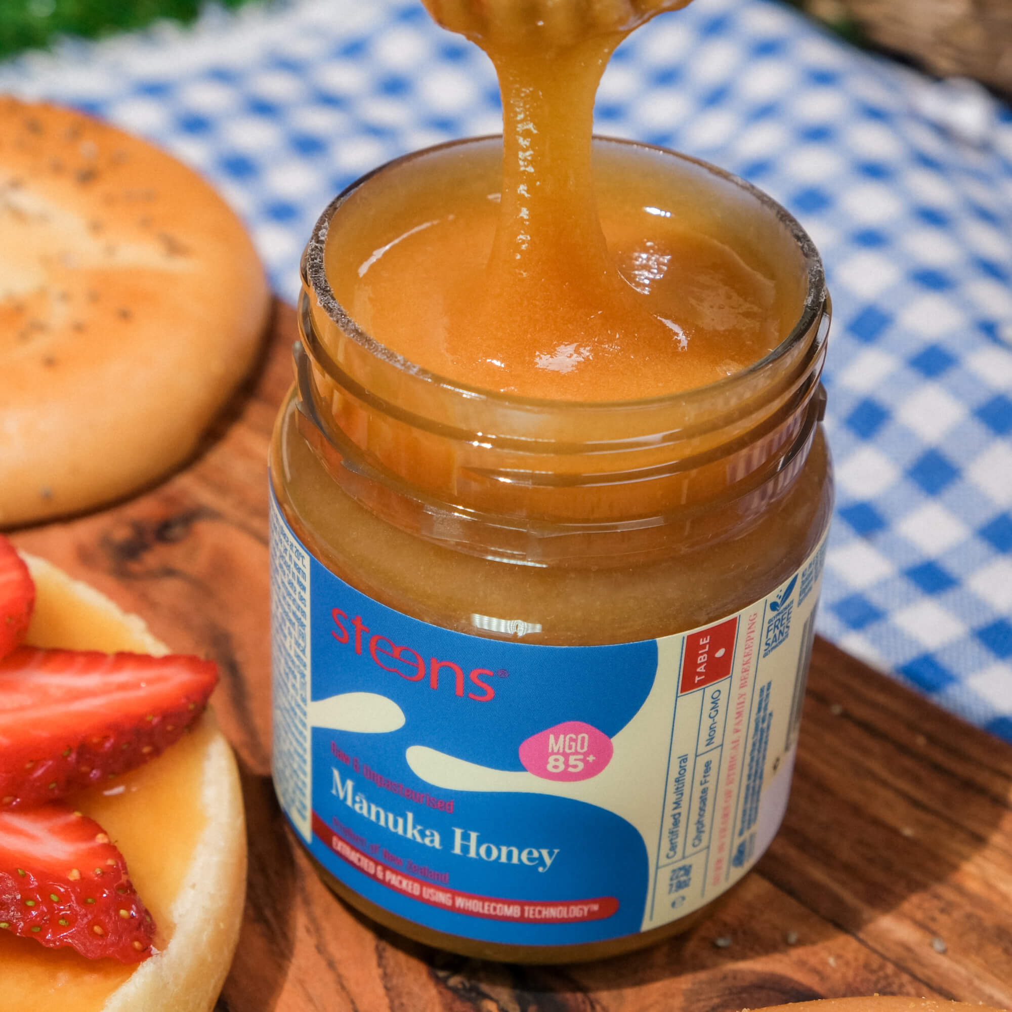 Jar of steens honey with honeycomb and plants on a light background
