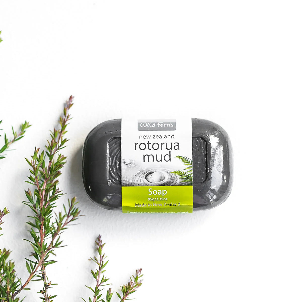 Wild Ferns Soap bar with 'Rotorua Mud' packaging on a white background with greenery.