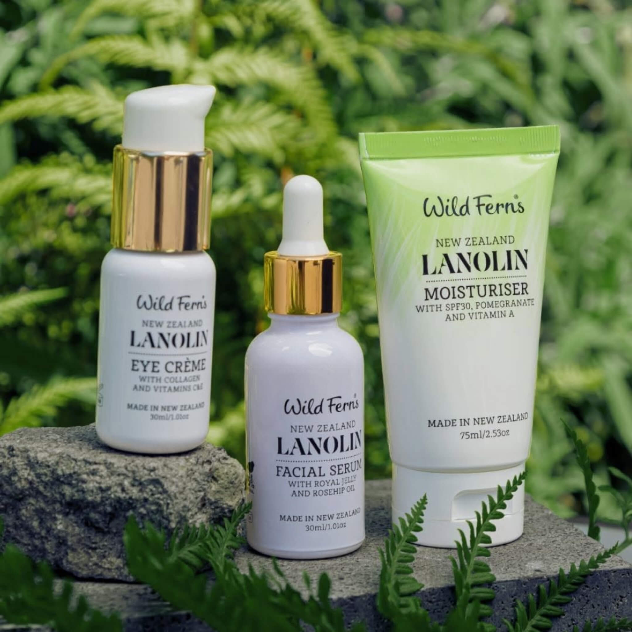 Wild Ferris skincare products including eye crème, facial serum, and moisturizer on a stone surface with greenery in the background.