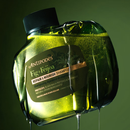 Antipodes Fig & Feijoa Repair & Nourish Shampoo bottle on a green background