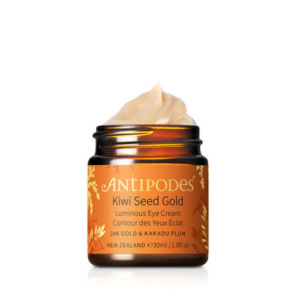 Antipodes Kiwi Seed Gold Eye Cream in a clear glass jar with a beige lid, label shows product name and ‘New Zealand’ text, eye cream is applied to the lid.
