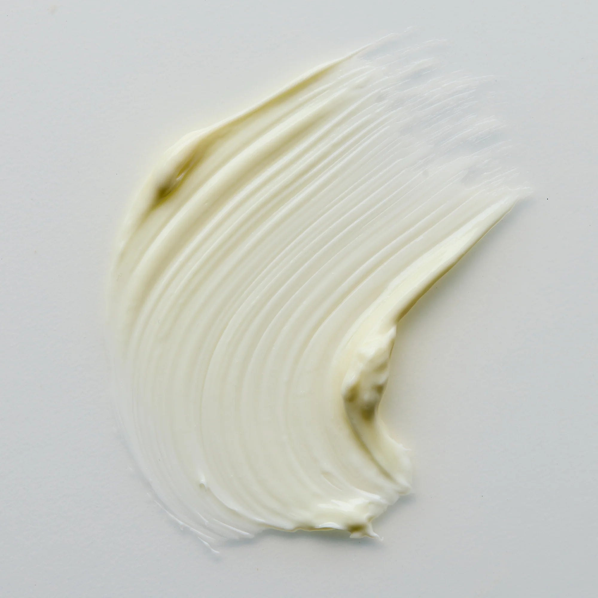 Close-up of a swatch of Antipodes Lime Cavier white cream on a light gray background