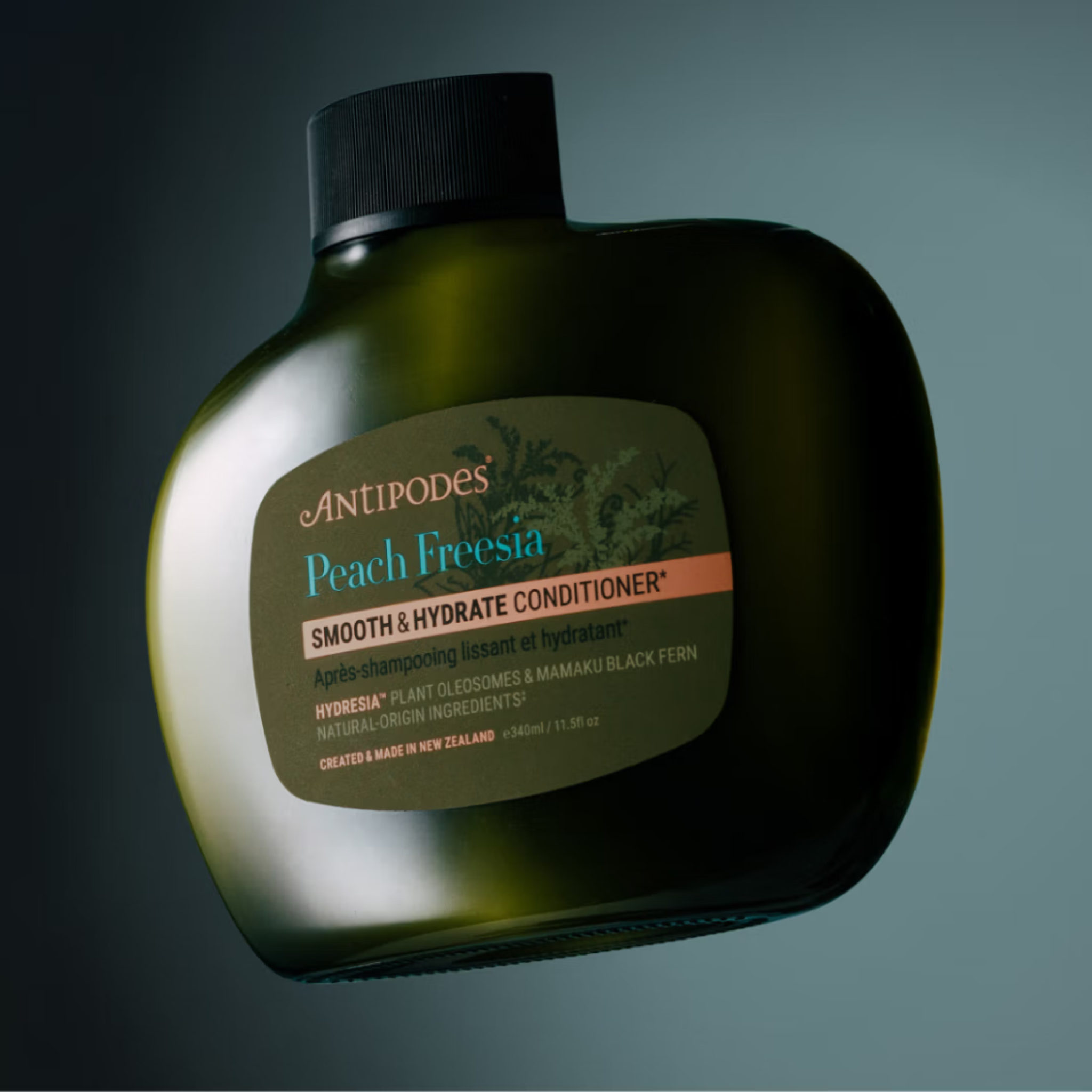 Antipodes Peach Fresia Smooth & Hydrate Conditioner bottle on a dark background