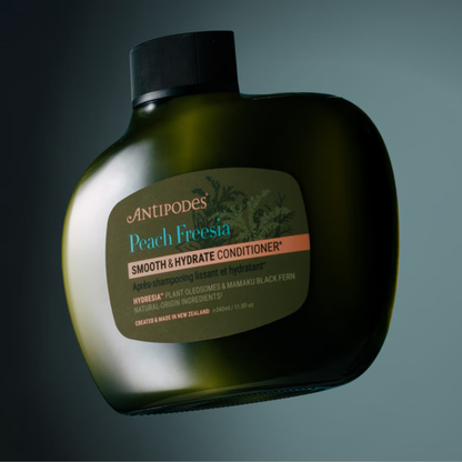 Antipodes Peach Fresia Smooth & Hydrate Conditioner bottle on a dark background