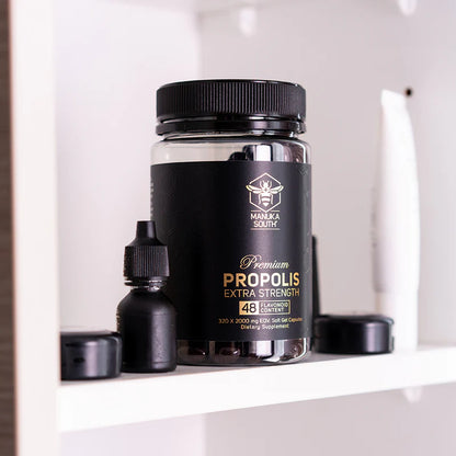 Black container of Manuka South  Propolis Soft Gel labeled 'Premium Propolis Extra Strength' on a white shelf.