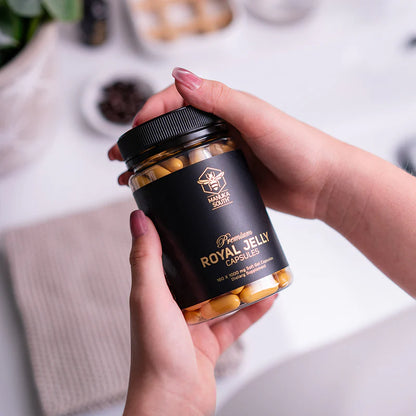 Person holding a jar of Manuka South Royal Jelly 160 Capsules with a blurred background