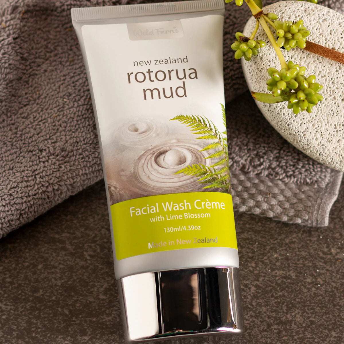 Tube of Wild Ferns Rotorua Mud Facial Wash Crème on a textured surface with greenery